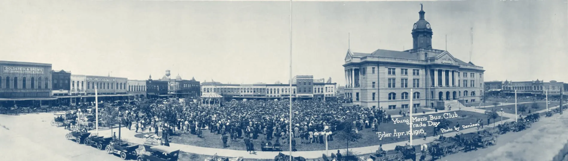 A panoramic photograph of a large crowd filling the courthouse square on Trade Day, April 10, 1916, in front of the domed Smith County courthouse, with storefronts, a bandstand, early cars and horse-drawn wagons around it.